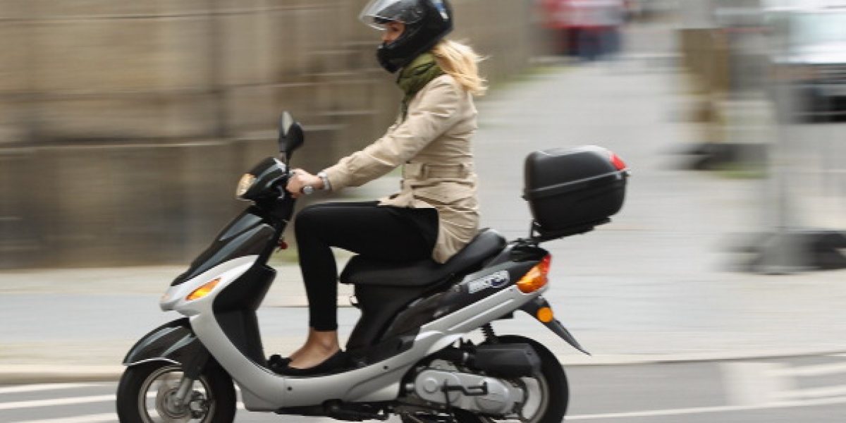 BERLIN, GERMANY - JULY 17:  A young woman rides a moped on July 17, 2012 in Berlin, Germany. Mopeds are a common mode of commuter transportation across Europe.  (Photo by Sean Gallup/Getty Images)