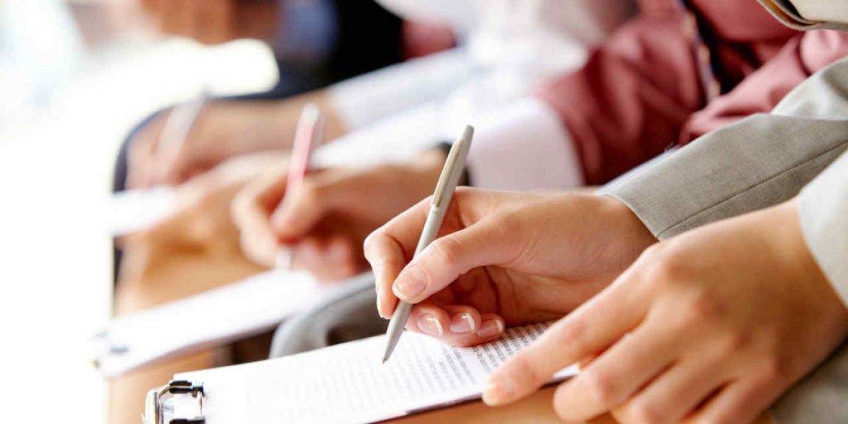 Businesspeople hands over papers making notes at seminar