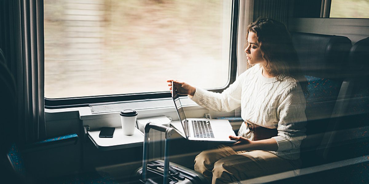 Freelancer girl working with laptop in the train, business travel or technology concept.